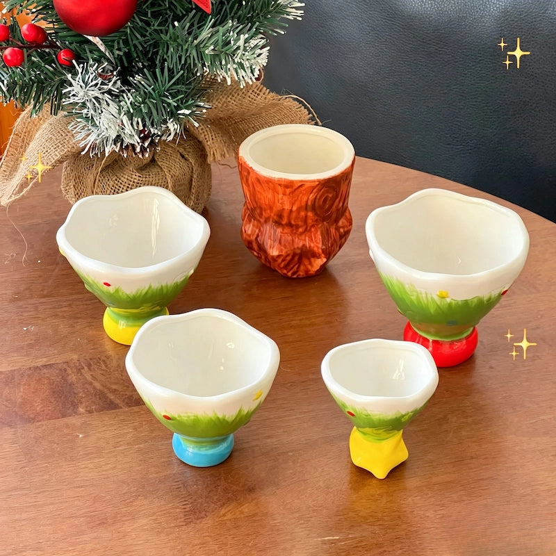 Five-piece ceramic Christmas tree cup set displayed with holiday decorations